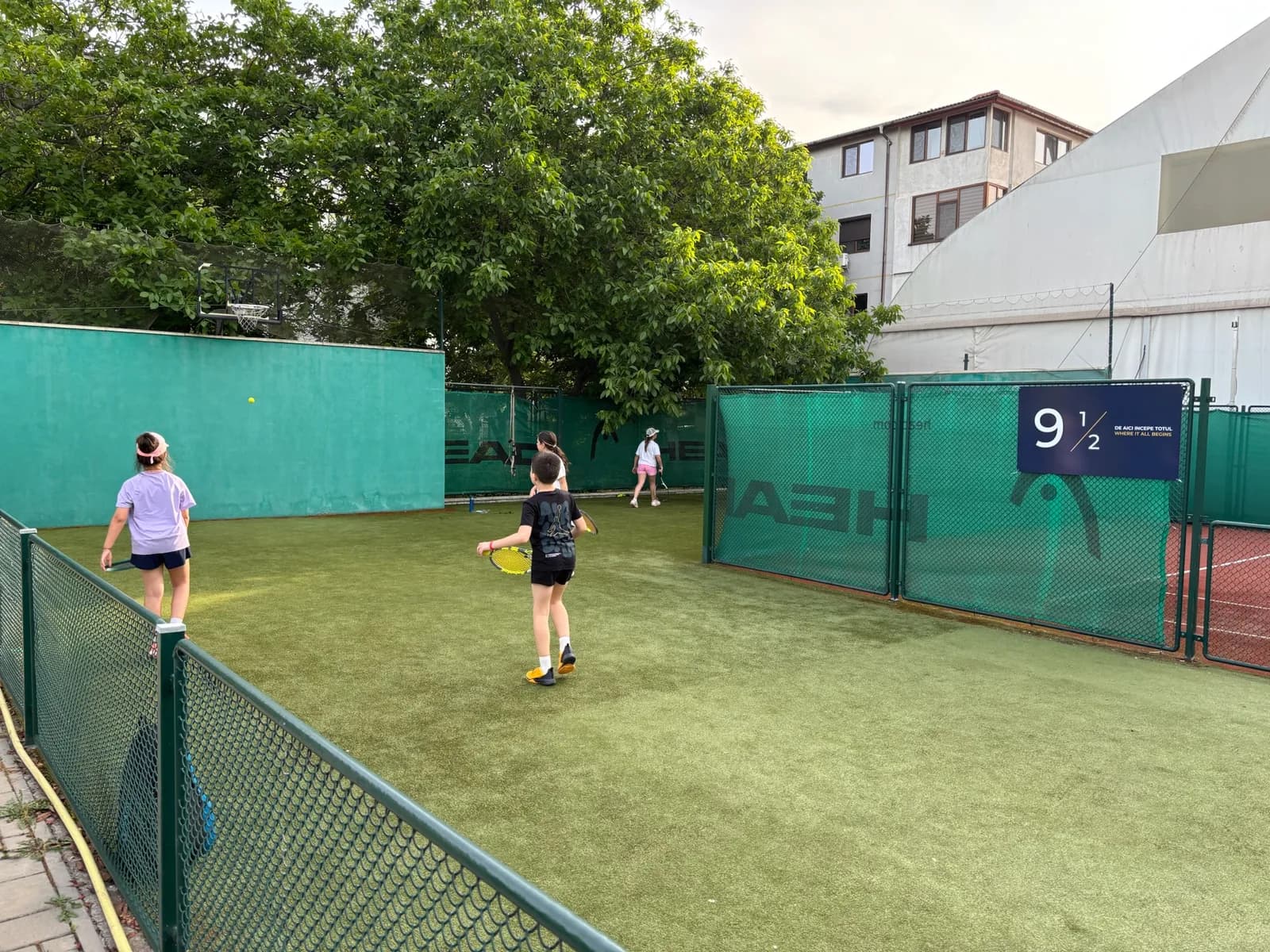 Copii la antrenament pe terenul de dimensiuni specifice nivelului începători, 9½ Tennis Club